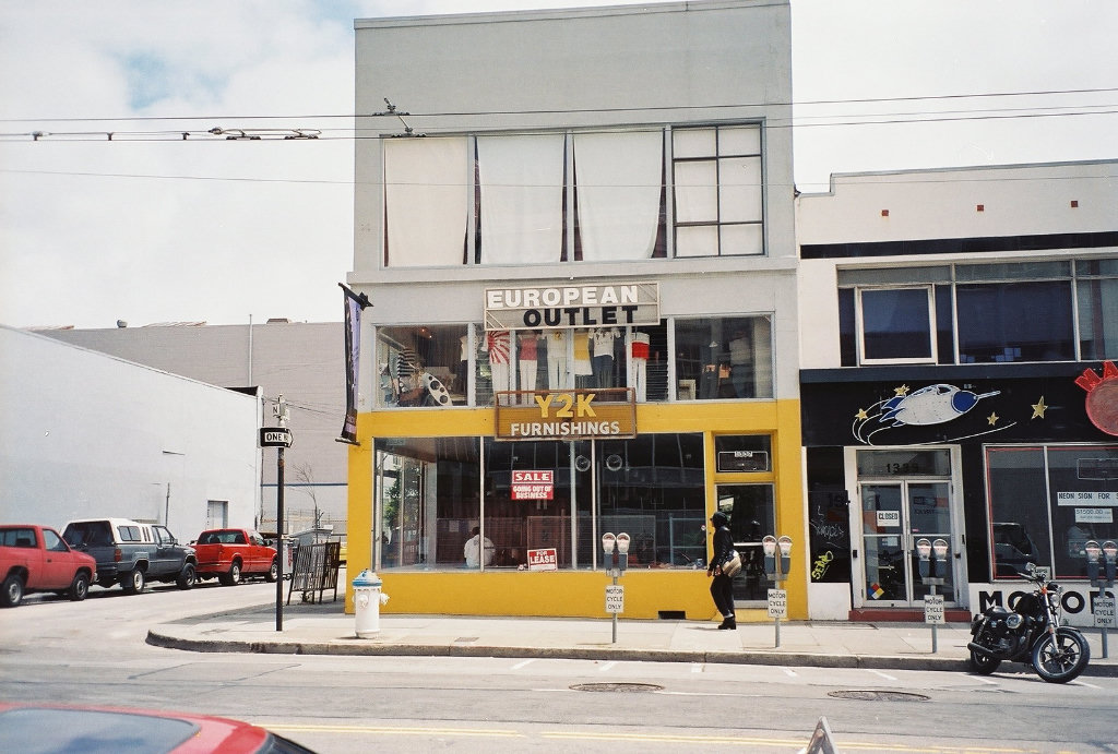 Photograph of store named 'Y2K Furnishings'. The storefront window shows signs that read 'SALE', 'GOING OUT OF BUSINESS' and 'FOR LEASE'.